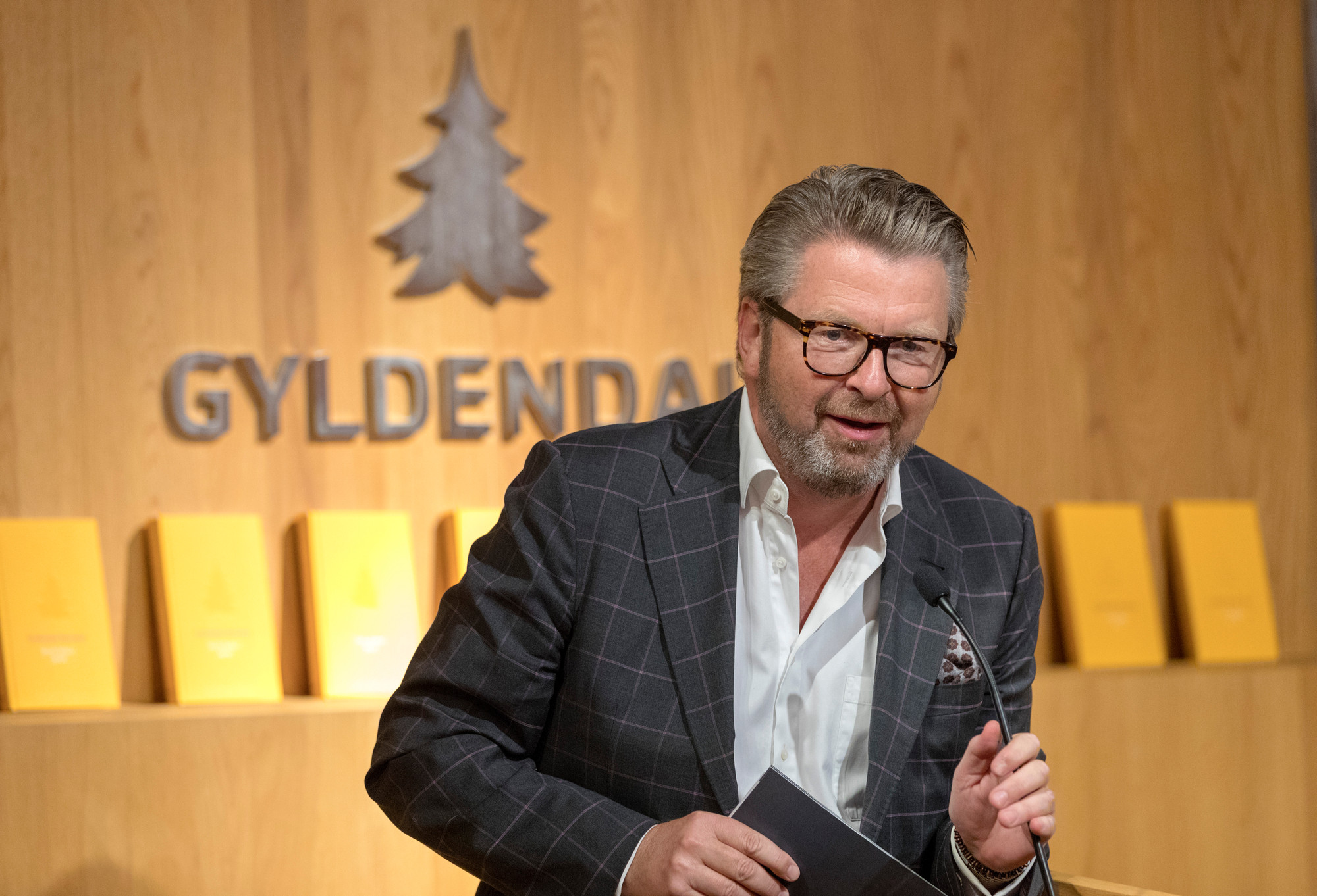 Portrett av Lars Røtterud med mikrofon i Gyldendals lokaler.