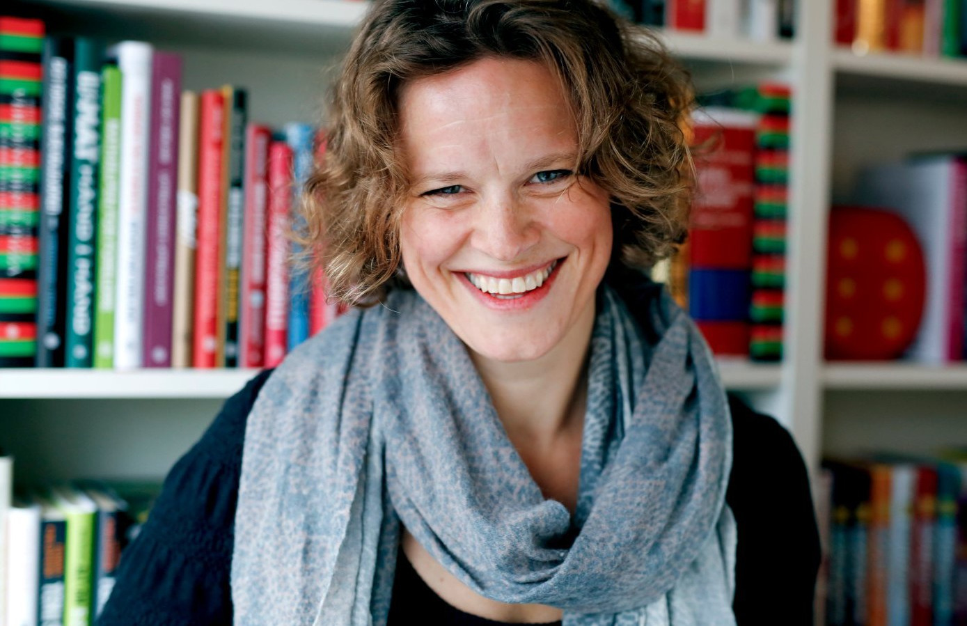Portrett av Tuva Sørheim foran bokhyller.