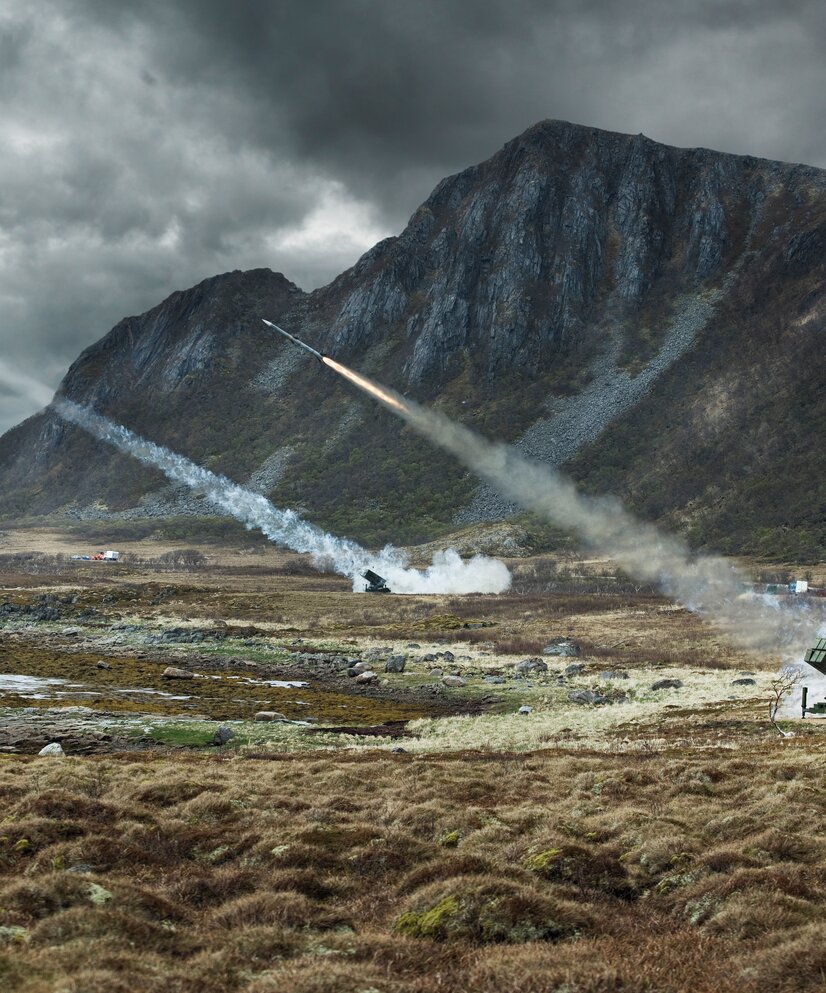 Bilde av utskyting av rakettar i eit fjell-landskap.